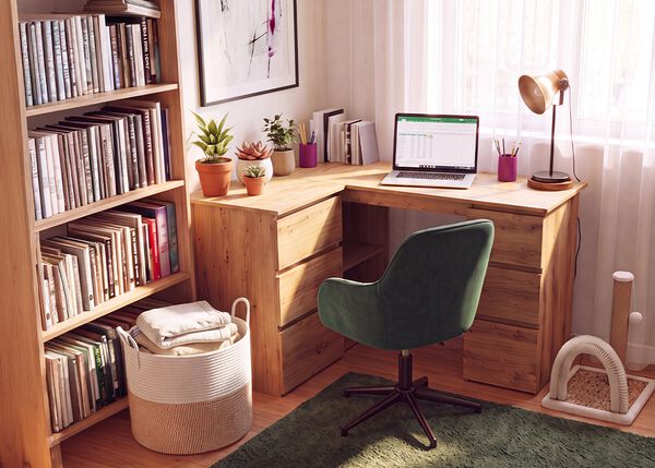 Home office with a wooden corner desk, ergonomic green office chair, laptop, bookshelf, desk lamp, and indoor plants, creating a comfortable and productive workspace for working from home.