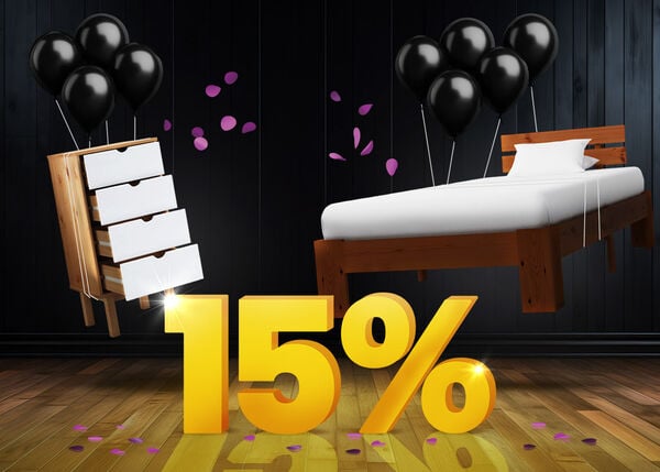 Chest of drawers and wooden bed frame with black balloons in front of a bright yellow 15% sign on a dark wooden floor.