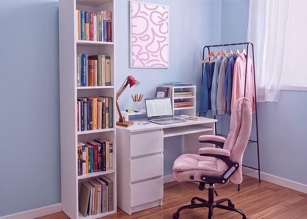 Modern student study space with a white desk, ergonomic office chair, laptop, bookshelf, storage unit, and clothing rack in a bright, organized bedroom designed for comfortable studying and everyday student life.