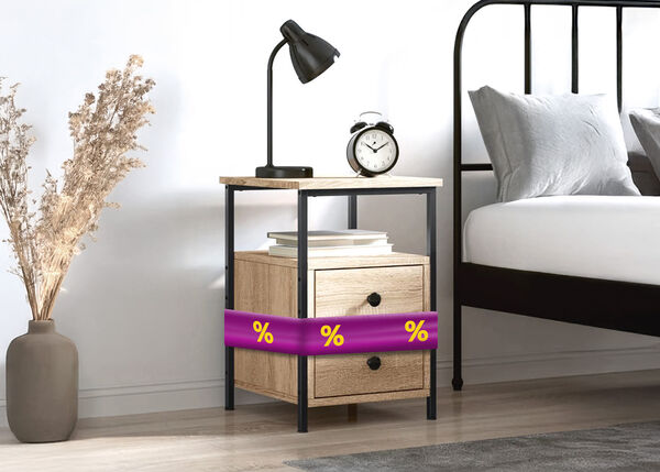 Bedside table with purple ribbon showing discount icons, next to metal bed in a styled bedroom.
