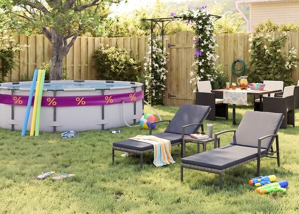 Sunny backyard garden with an above-ground swimming pool, pool noodles, goggles, beach ball, and flip-flops on the grass. Two black metal sun loungers with grey cushions sit beside a small side table, while an outdoor dining set with dark rattan chairs is arranged near a flowering pergola, wooden fence, garden plants, and summer party accessories.