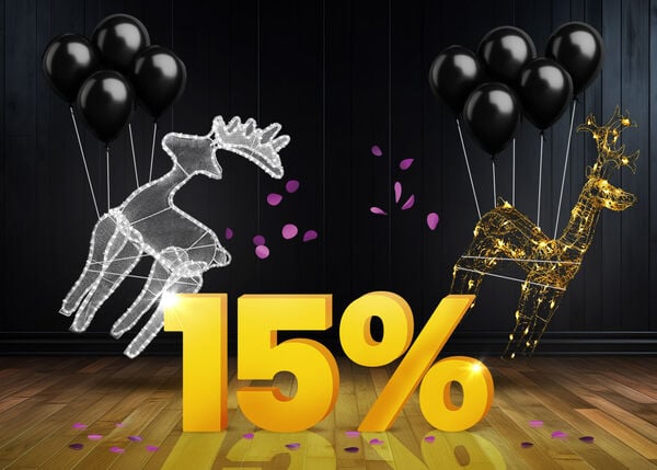 Luminous reindeer decorations and black balloons in front of a bright yellow 15% sign on a dark wooden floor.