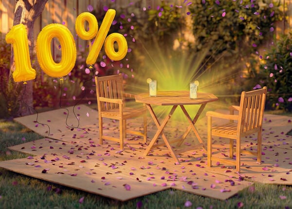 Wooden outdoor dining table with two matching chairs in a garden setting, decorated with pink confetti and golden 10% discount balloons, highlighting a seasonal sale on outdoor dining furniture.
