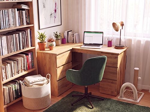 Home office with a wooden corner desk, ergonomic green office chair, laptop, bookshelf, desk lamp, and indoor plants, creating a comfortable and productive workspace for working from home.
