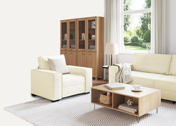 White 2-seater sofa with pillows and a throw blanket, indoors.