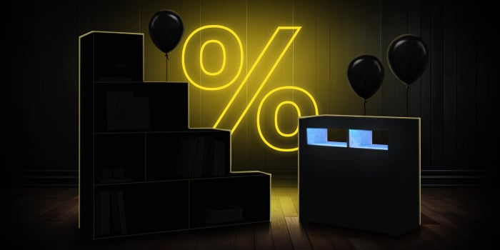 Black modular storage units with black balloons in front of a bright pink percentage symbol on a dark wooden floor.