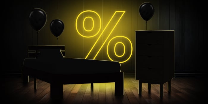 Black bed and dresser with black balloons in front of a bright pink percentage symbol on a dark wooden floor.