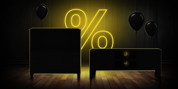 Black dresser and TV stand with black balloons in front of a bright pink percentage symbol on a dark wooden floor.